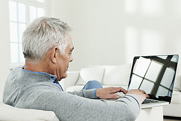 Deutschland, Berlin, Älterer Mann mit Laptop - FMKYF000021