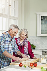 Germany, Berlin, Man and woman preparing food, smiling - FMKYF000032