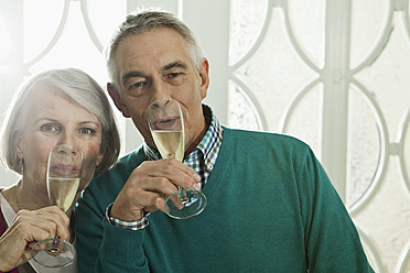 Germany, Berlin, Senior couple drinking champagne, portrait - FMKYF000059