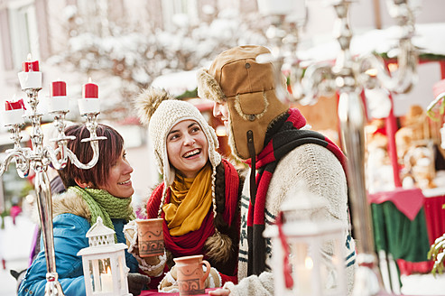 Austria, Salzburg, Man and women at christmas market, smiling - HHF004193