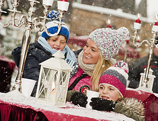 Austria, Salzburg, Mother with children at christmas market, smiling - HHF004196