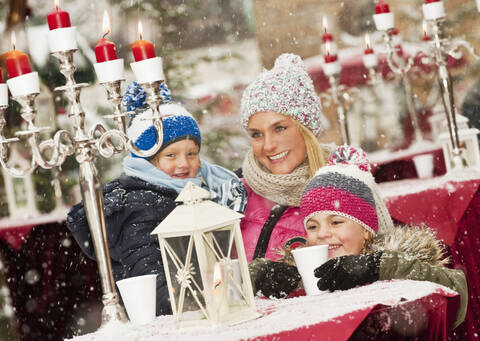 Austria, Salzburg, Mother with children at christmas market, smiling stock photo