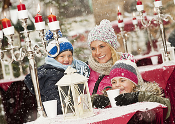 Austria, Salzburg, Mother with children at christmas market, smiling - HHF004197