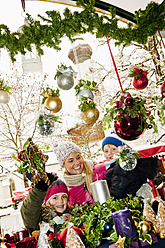 Austria, Salzburg, Mother with children at christmas market, smiling - HHF004199