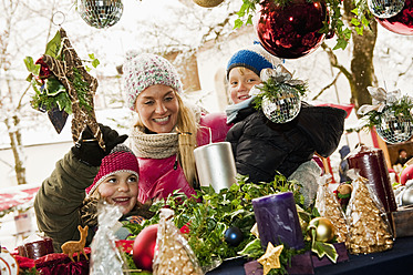 Austria, Salzburg, Mother with children at christmas market, smiling - HHF004200