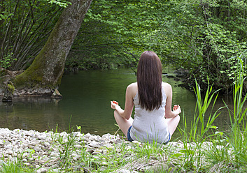 Austria, Young woman doing meditation - WWF002416