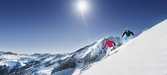 Österreich, Salzburg, Junges Paar beim Skifahren am Berg - HHF004184