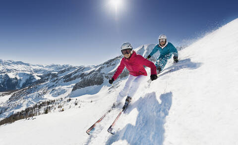 Austria, Salzburg, Young couple skiing on mountain stock photo