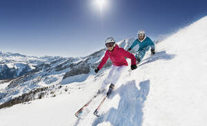 Österreich, Salzburg, Junges Paar beim Skifahren am Berg - HHF004185
