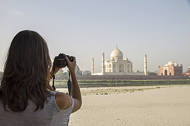 Indien, Agra, Junge Frau beim Fotografieren des Taj Mahal - MBEF000344