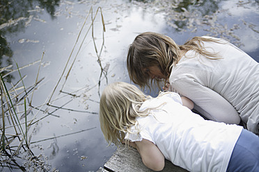 Deutschland, Bayern, Mutter und Tochter schauen in den Teich - TCF002703