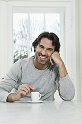 Germany, Berlin, Mature man with coffee cup, smiling, portrait - FMKYF000112