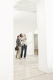 Germany, Berlin, Mature couple inspecting new house - FMKYF000155