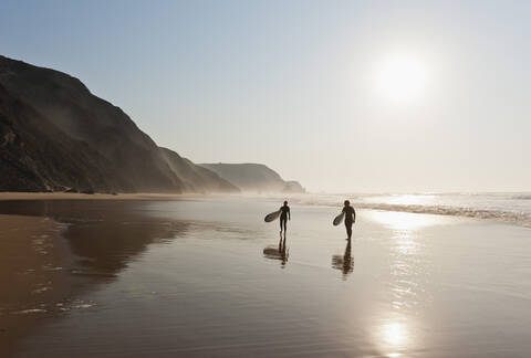 Portugal, Pärchen mit Surfbrett am Strand, lizenzfreies Stockfoto