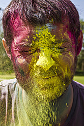 India, Ahmedabad, Man celebrates Holi festival with powder paints - MBEF000352