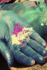 India, Ahmedabad, Young woman holding powder paint on holi festival - MBEF000367