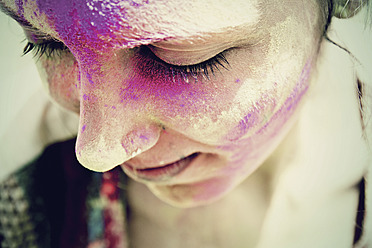 India, Ahmedabad, Young woman celebrating holi festival with powder paint - MBEF000366