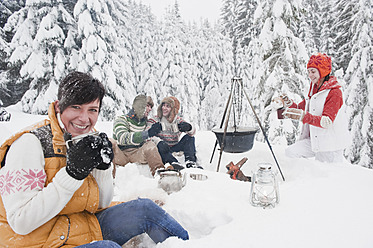 Österreich, Salzburg, Männer und Frauen sitzen am Kamin im Winter - HHF004211