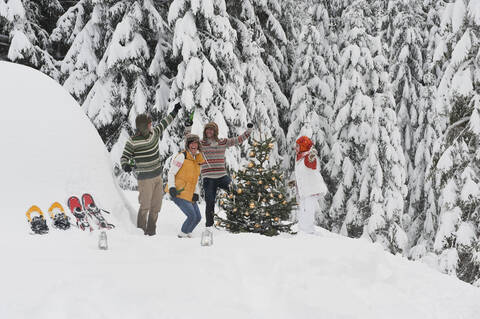 Österreich, Salzburg, Männer und Frauen tanzen am Weihnachtsbaum im Winter, lizenzfreies Stockfoto