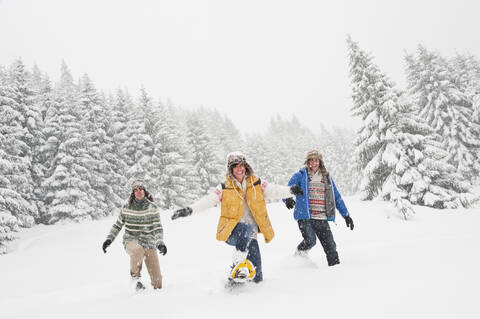 Austria, Salzburg, Men and woman walking through winter landscape stock photo