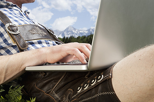 Deutschland, Bayern, Mittlerer Erwachsener Mann mit Laptop - RBF000929