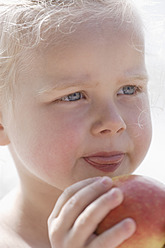 Germany, Bavaria, Girl eating apple, close up - TCF002736