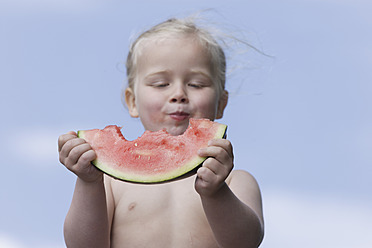 Deutschland, Bayern, Mädchen isst ein Stück Wassermelone - TCF002776