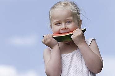 Deutschland, Bayern, Mädchen isst ein Stück Wassermelone - TCF002774