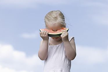 Deutschland, Bayern, Mädchen isst ein Stück Wassermelone - TCF002773