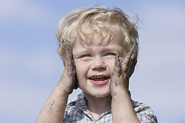 Germany, Bavaria, Boy playing with charcoal, smiling - TCF002753