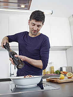 Deutschland, Köln, Mittlerer Erwachsener Mann beim Kochen in der Küche - RHYF000113