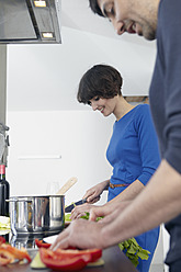 Germany, Cologne, Man and woman cooking together in kitchen - RHYF000122