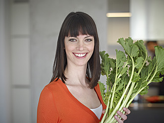 Deutschland, Köln, Mittlere erwachsene Frau mit Gemüse, lächelnd, Porträt - RHYF000125