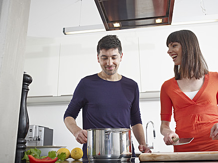 Deutschland, Köln, Mann und Frau kochen gemeinsam in der Küche - RHYF000127