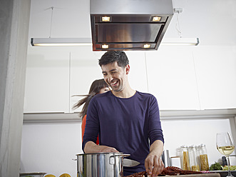 Deutschland, Köln, Mann und Frau kochen gemeinsam in der Küche - RHYF000128