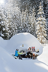 Österreich, Salzburger Land, Vater und Sohn sitzen bei Iglu - HHF004233