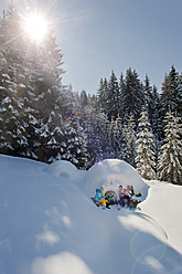 Österreich, Land Salzburg, Familie sitzt bei Iglu - HHF004234