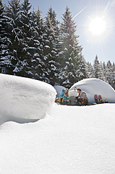 Österreich, Salzburger Land, Paar sitzt bei Iglu - HHF004235