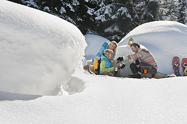 Österreich, Land Salzburg, Familie sitzt bei Iglu - HHF004240