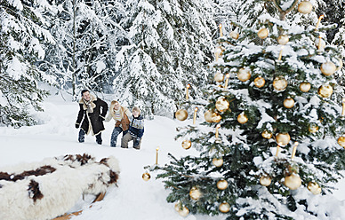 Österreich, Land Salzburg, Familie feiert Weihnachten im Schnee - HHF004245