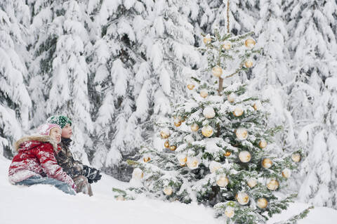 Austria, Salzburg County, Boy and girl watching christmas tree in snow stock photo
