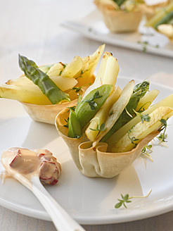 Gebackener Korb gefüllt mit Spargel und Kartoffelsalat auf einem Teller, Nahaufnahme - KSWF000921