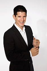 Mid adult man in black suit, smiling, portrait - NDF000263