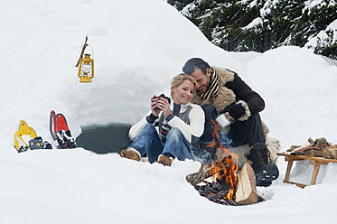 Austria, Salzburg County, Couple sitting near fireplace - HHF004259