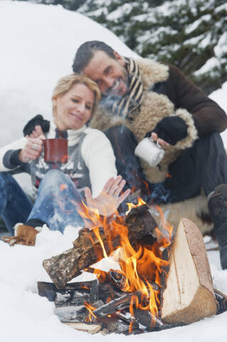 Austria, Salzburg County, Couple sitting near fireplace, smiling stock photo