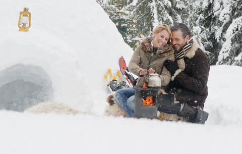 Austria, Salzburg County, Couple sitting near fireplace, smiling stock photo