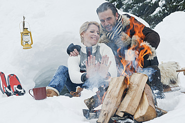 Austria, Salzburg County, Couple sitting near fireplace - HHF004262