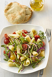 Plate of campanelle salad with wild asparagus and naan on table - KSWF000956