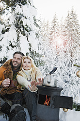 Österreich, Salzburger Land, Pärchen sitzt am Campingkocher und trinkt Tee - HHF004300