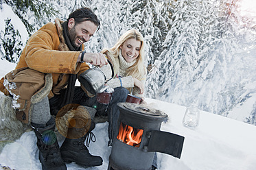 Austria, Salzburg County, Couple sitting near camping stove and drinking tea - HHF004301